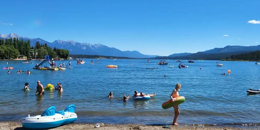 People playing and having fun on a lake and beach somewhere in the Rockies.